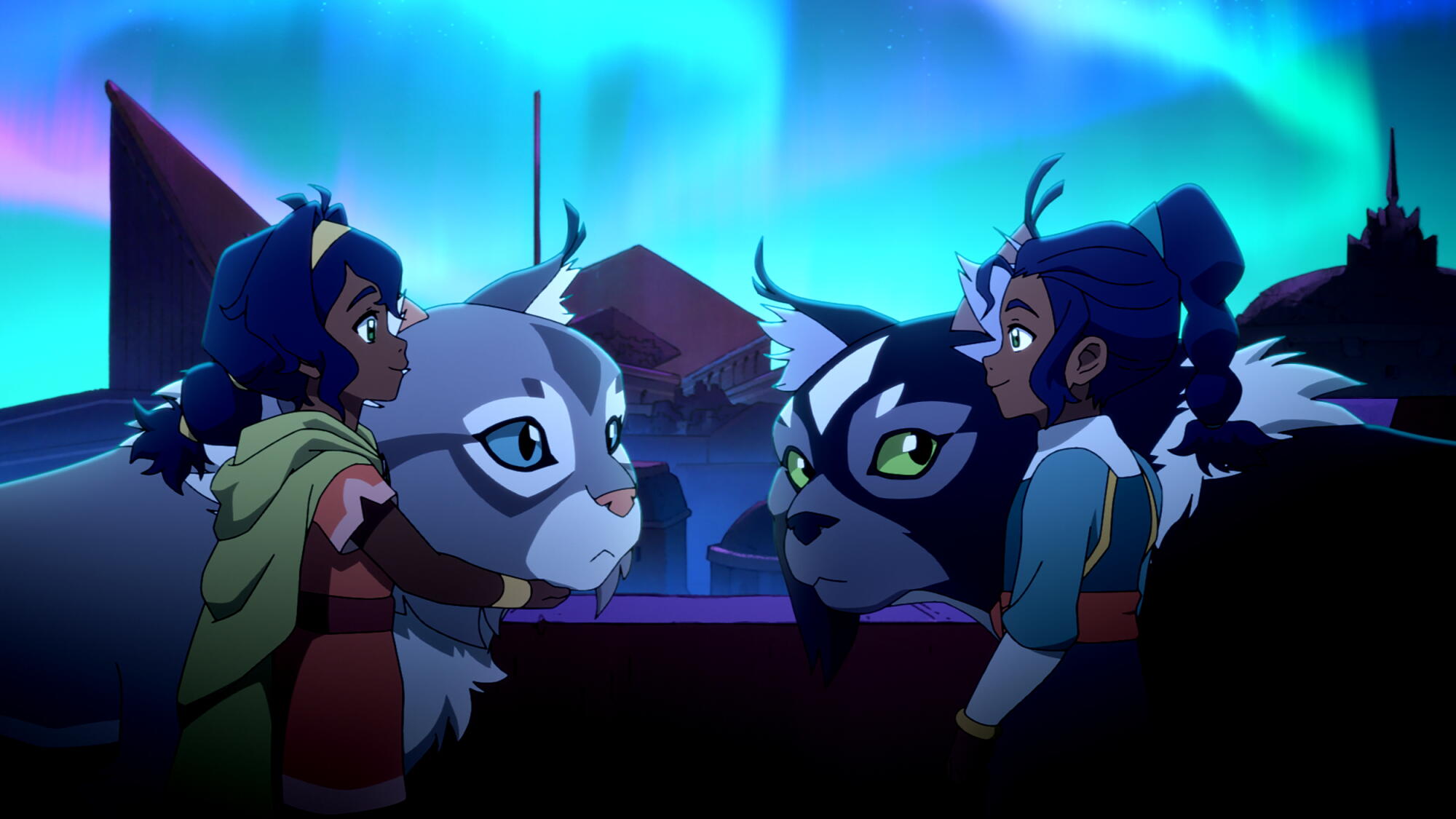 Two girls with their giant cats stand face to face. The sky in the background is a bright blue.