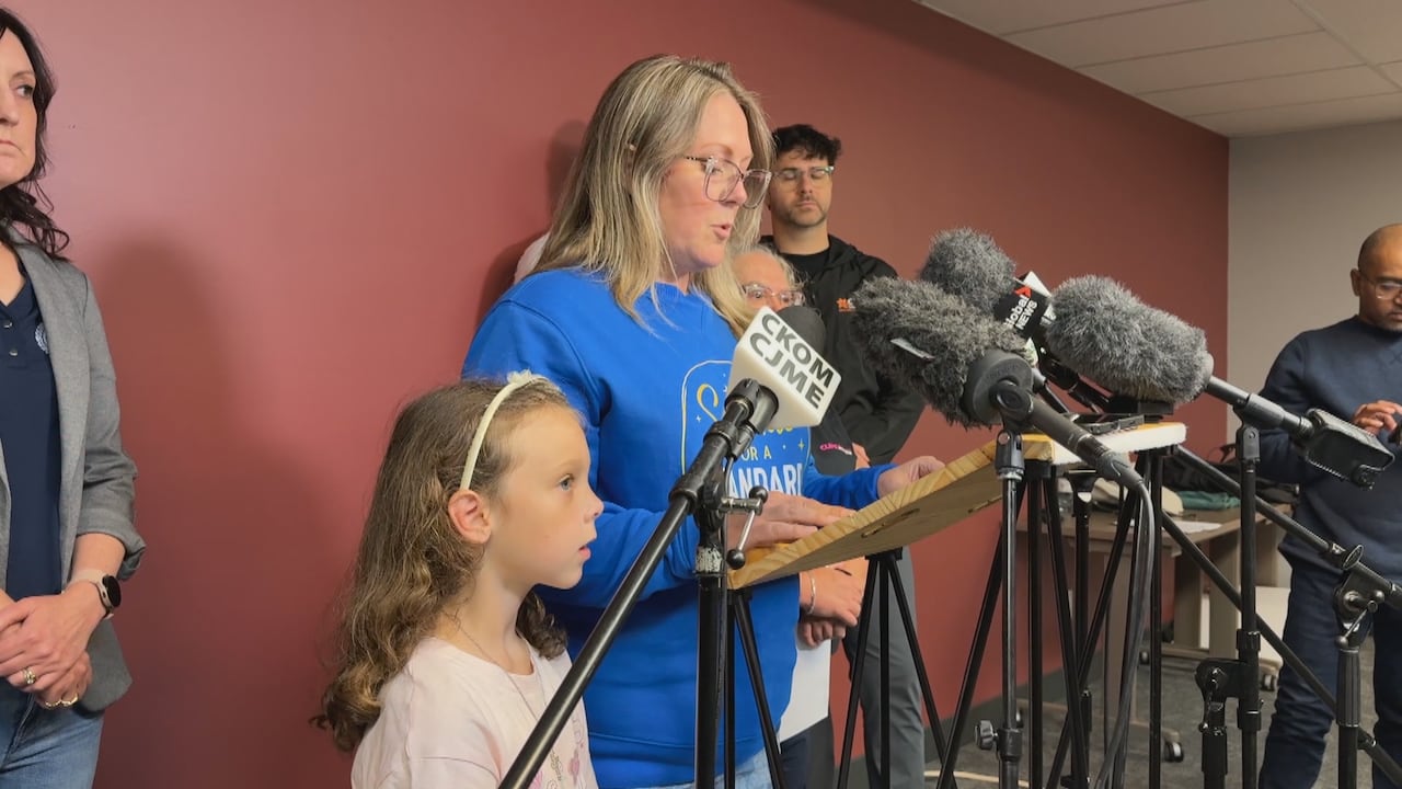 A woman and girl talk at a podium.