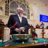 The Rev. John Jackman, a man with a white beard and hair, and a boy of about 9 in a Scout uniform are shown on the altar of a church, with colorful confetti floating around them. 
