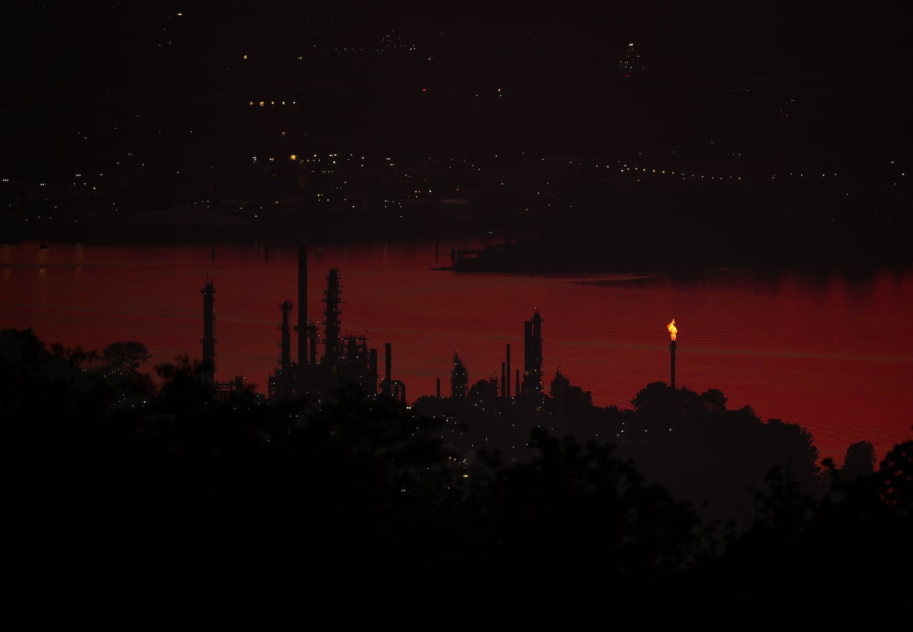 A flare stack burns at Parkland Corporation's Burnaby Refinery at sunset as smoke from wildfires burning in Canada and the U.S. begins to settle over the region, in Burnaby, B.C., on Tuesday, July 21, 2026.