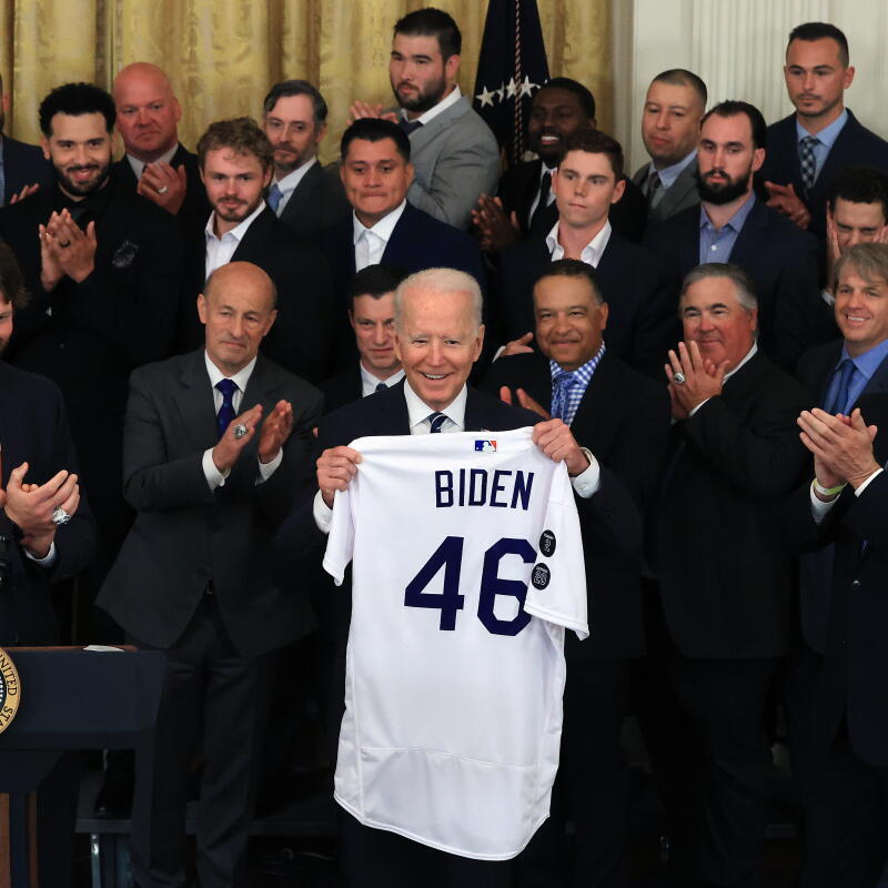 President Joe Biden (C) holds the jersey given to him by Los Angeles Dodgers Chairman Mark Walter
