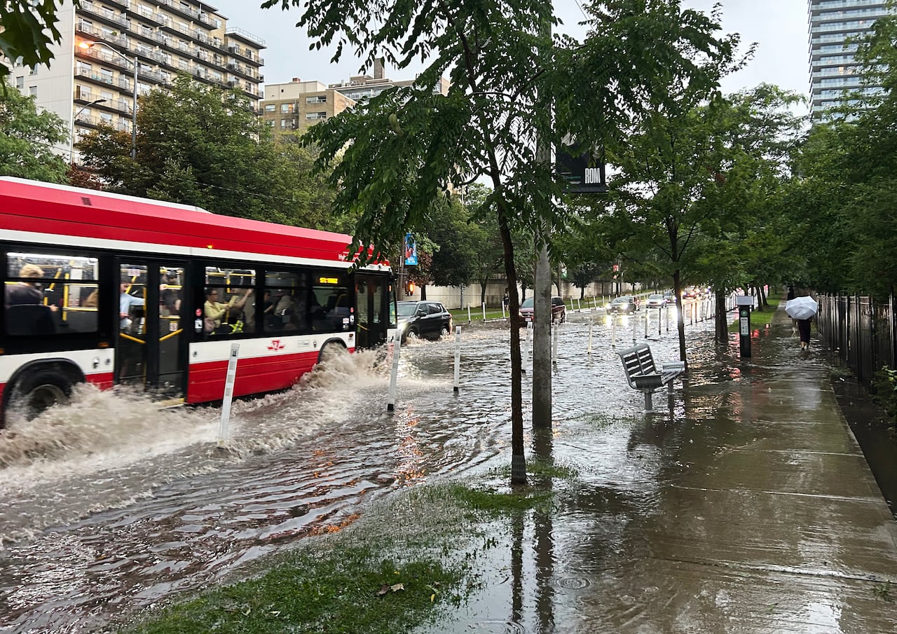 A transit bus drives through flood water along Yonge St. in midtown Toronto during a storm on Wednesday, Sept. 2, 2026.