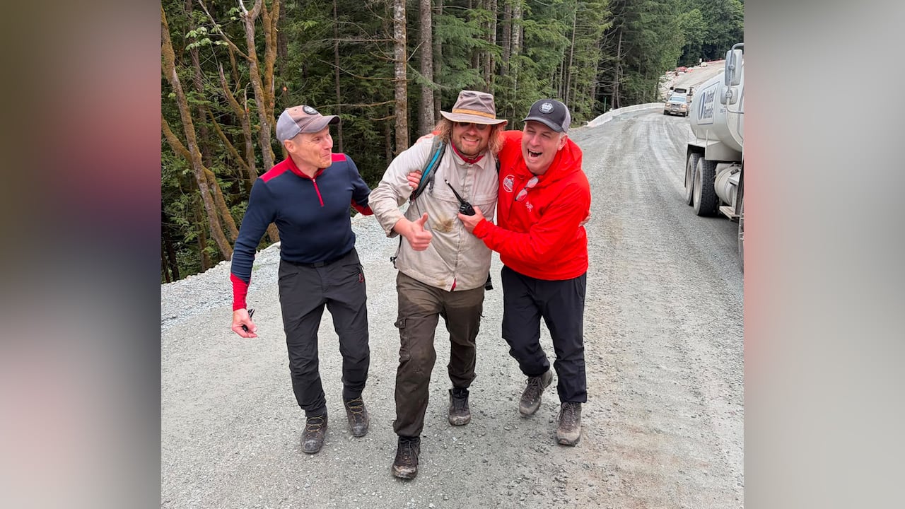 Men walk along a gravel road.