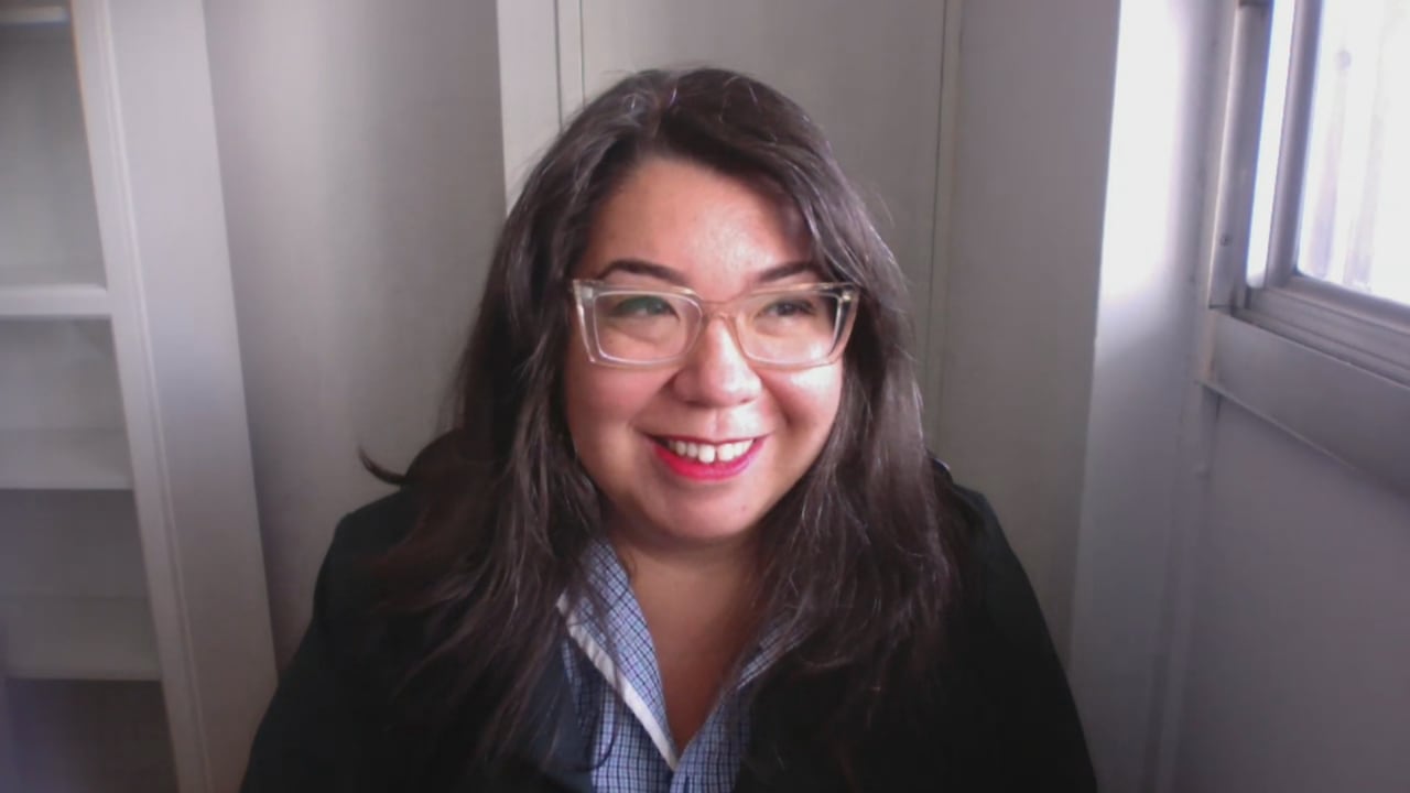 A woman with brown hair and clear glasses