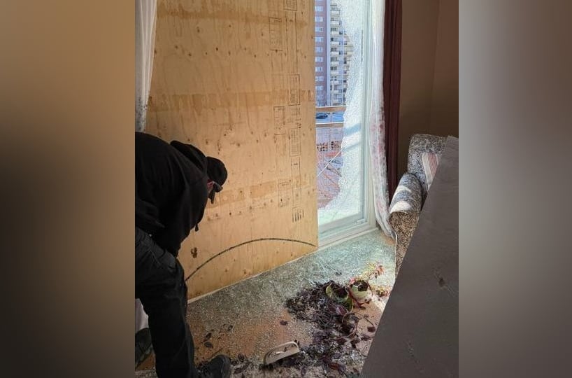 A worker boards up a window.