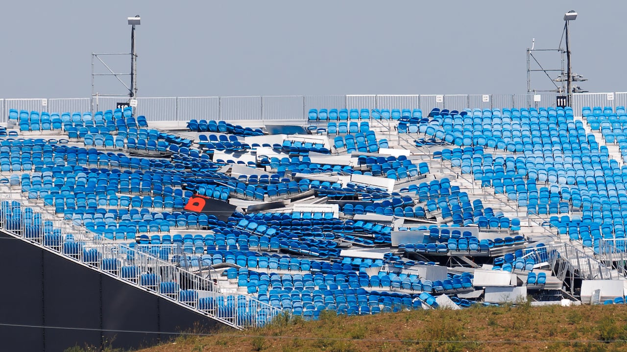 A set of blue bleachers at an outdoor venue lie in disarray and damaged.