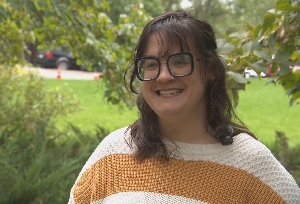A woman stands in a park for an interview.