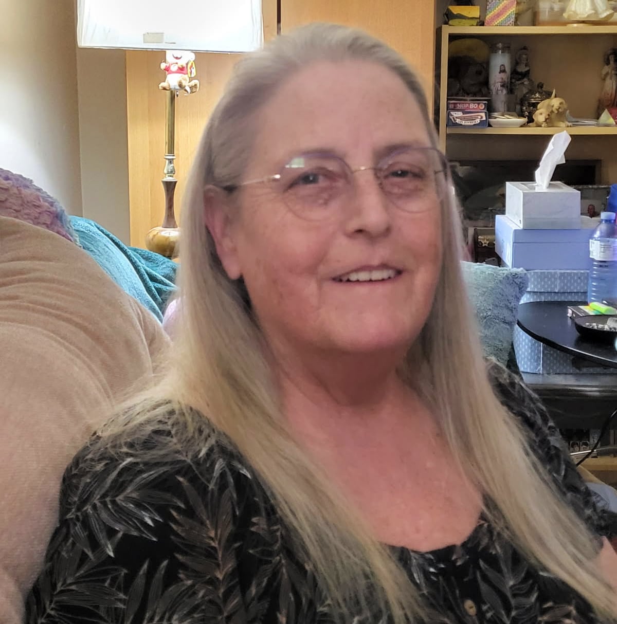 A woman with blondish-brown hair and glasses looks at the camera.