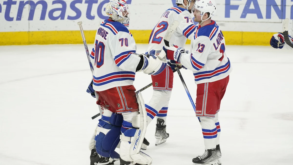 New York Rangers goaltender Louis Domingue (70) and left wing Alexis Lafrenire (13) celebrate their win against the Chicago Blackhawks at United Center.