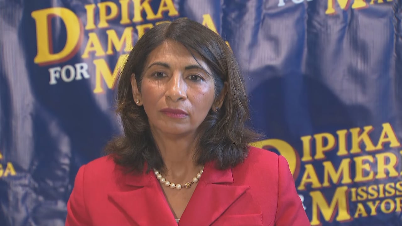 Woman in blazer standing in front of roll-up banner