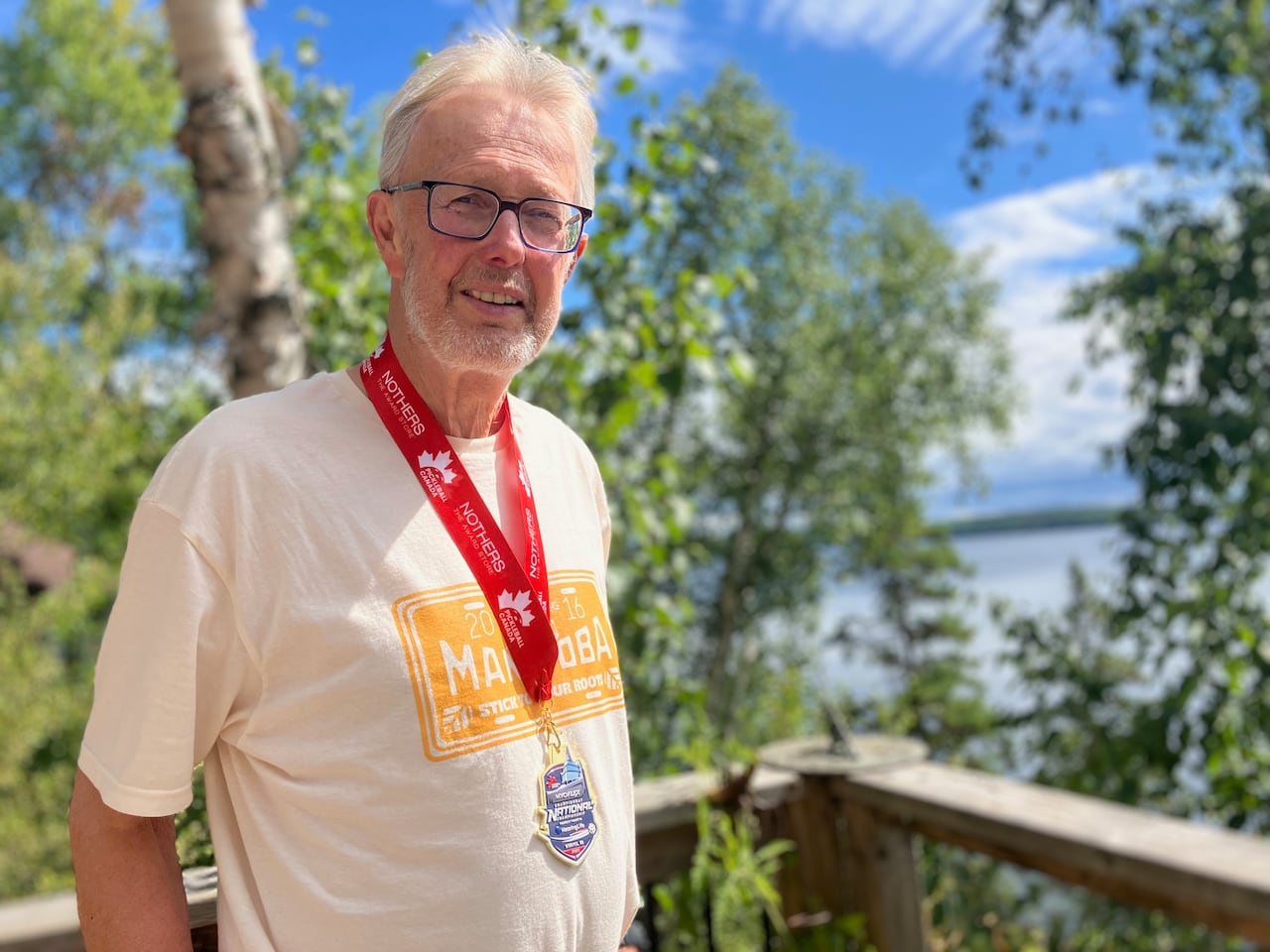 A man smiles with a medal on his neck.