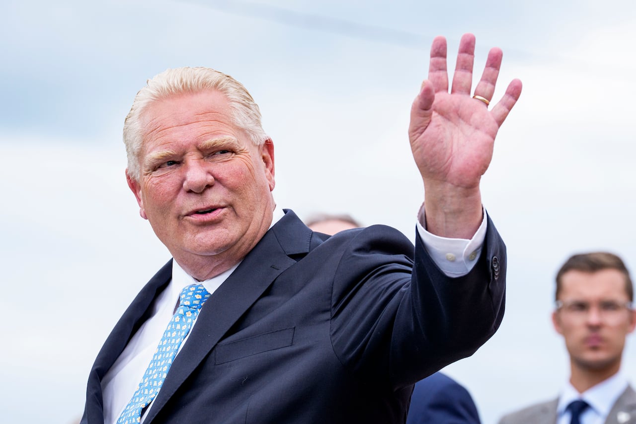 Man dressed in suit waving off to the side