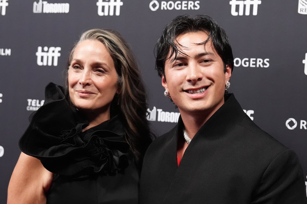 A man and a woman smile on the red carpet.
