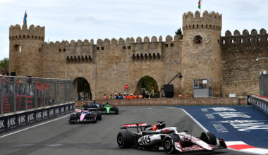 F1 cars driving around the Baku Street Circuit with the Maiden Tower in the background.