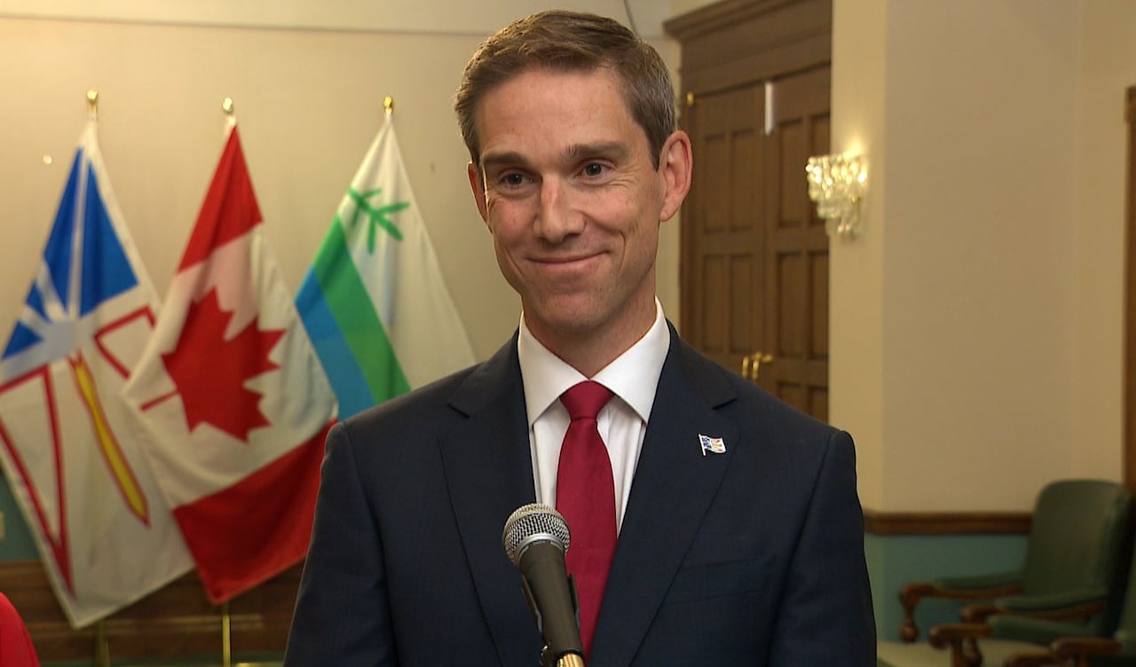 Man in suit smiling in front of microphone
