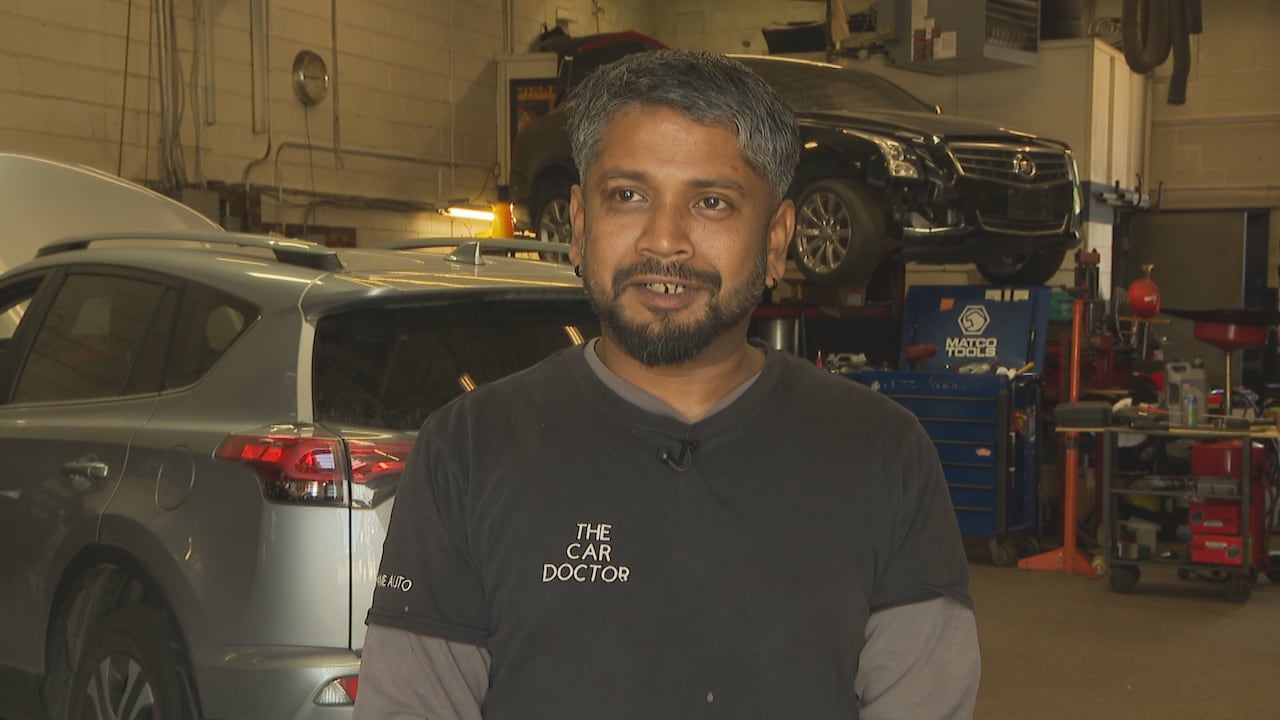 Man smiling in a mechanic shop