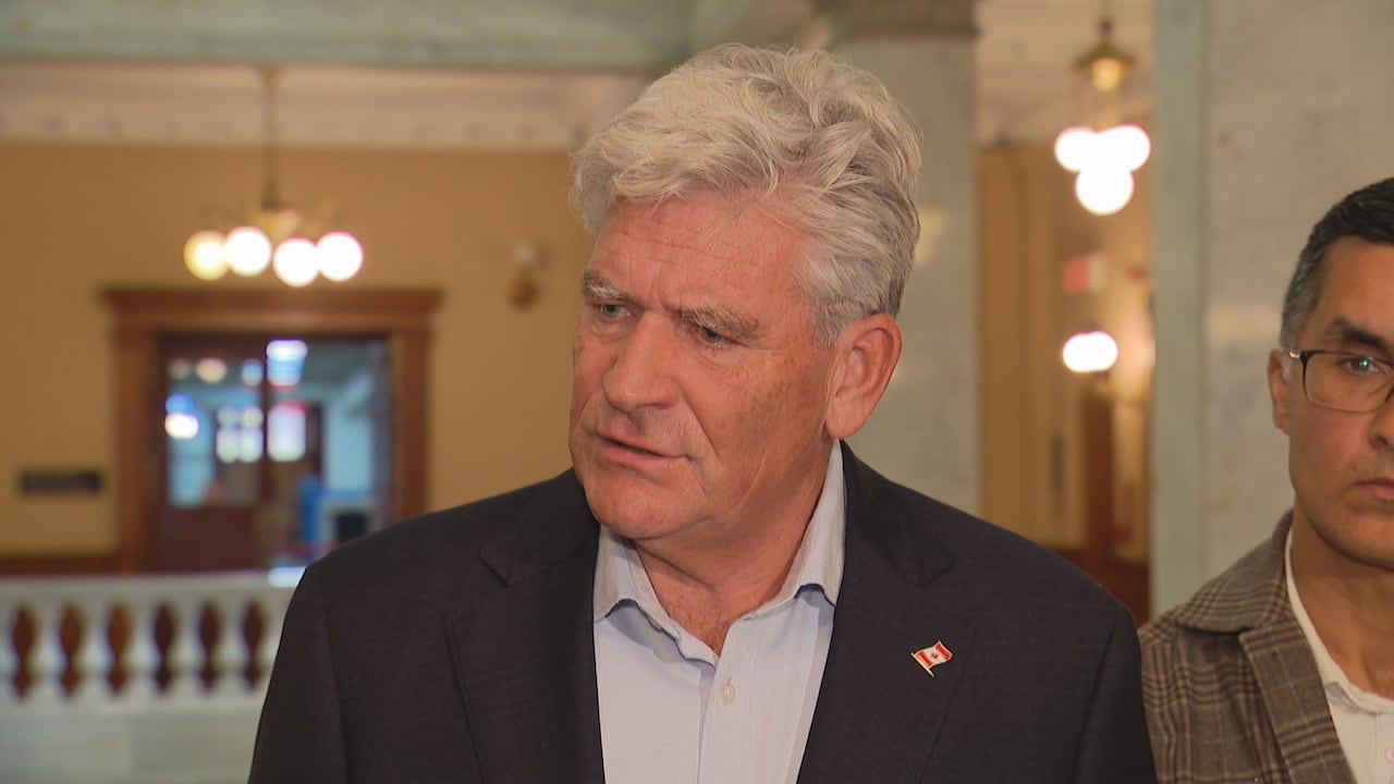 Man at podium with white hair.