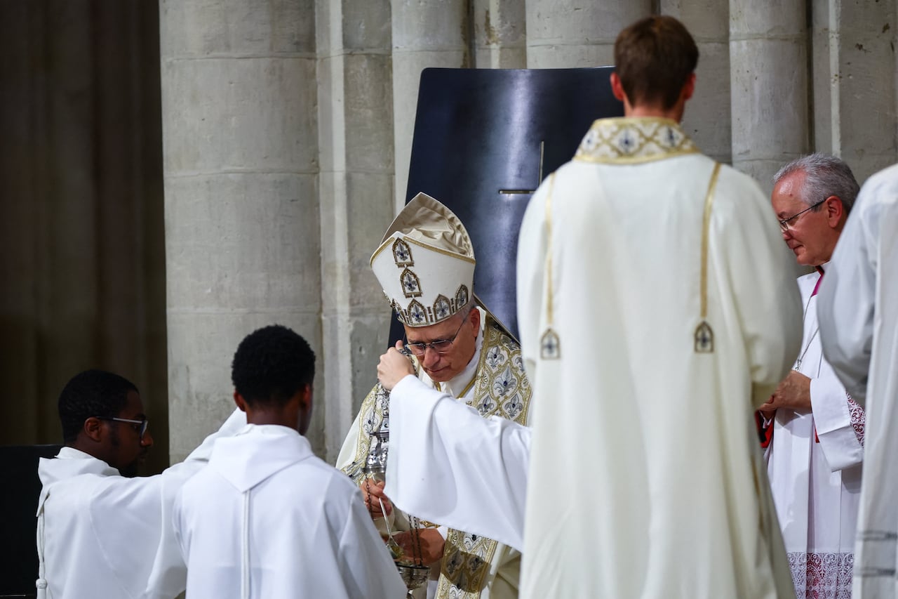 A religious ceremony scene is shown with boys wearing robes and older men wearing robes and religious headcoverings.