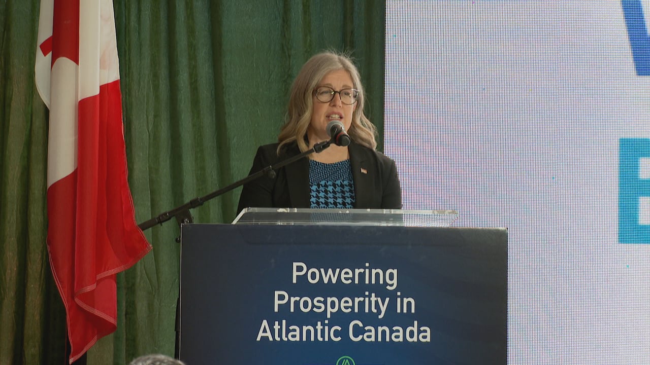 a woman at a podium with words "powering prosperity in atlantic canada"
