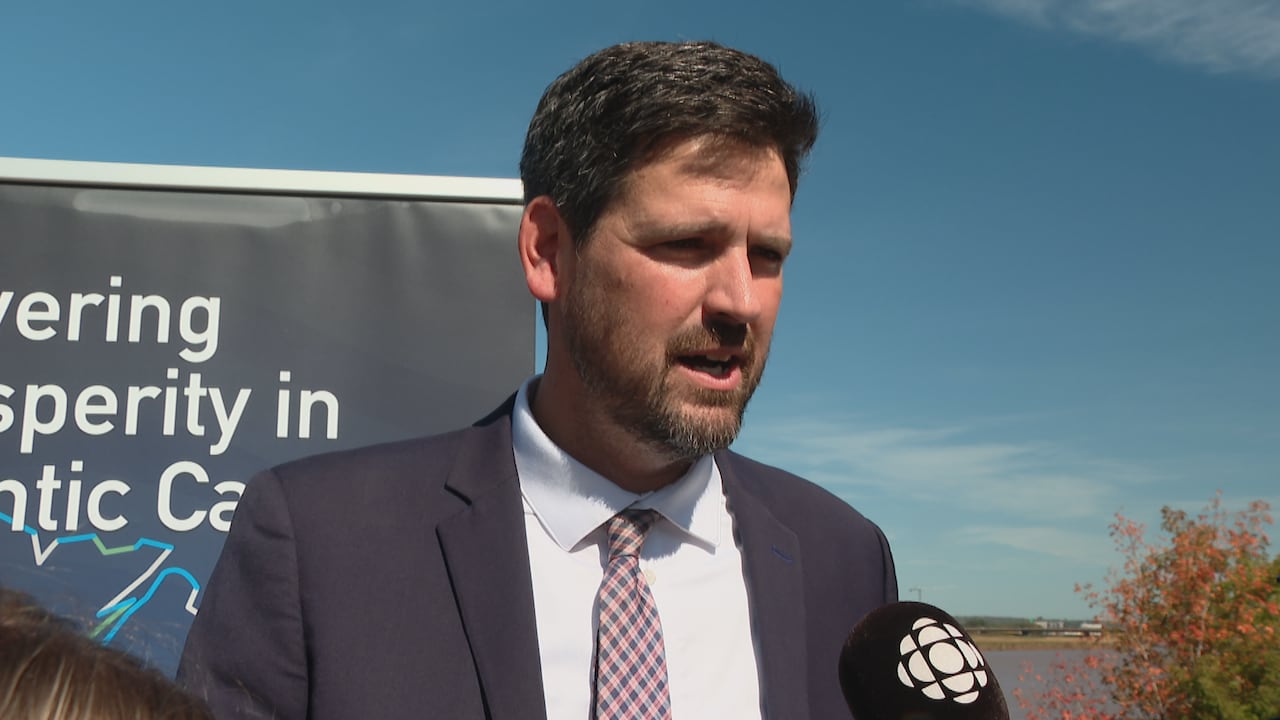 a man speaking into a cbc microphone, outside