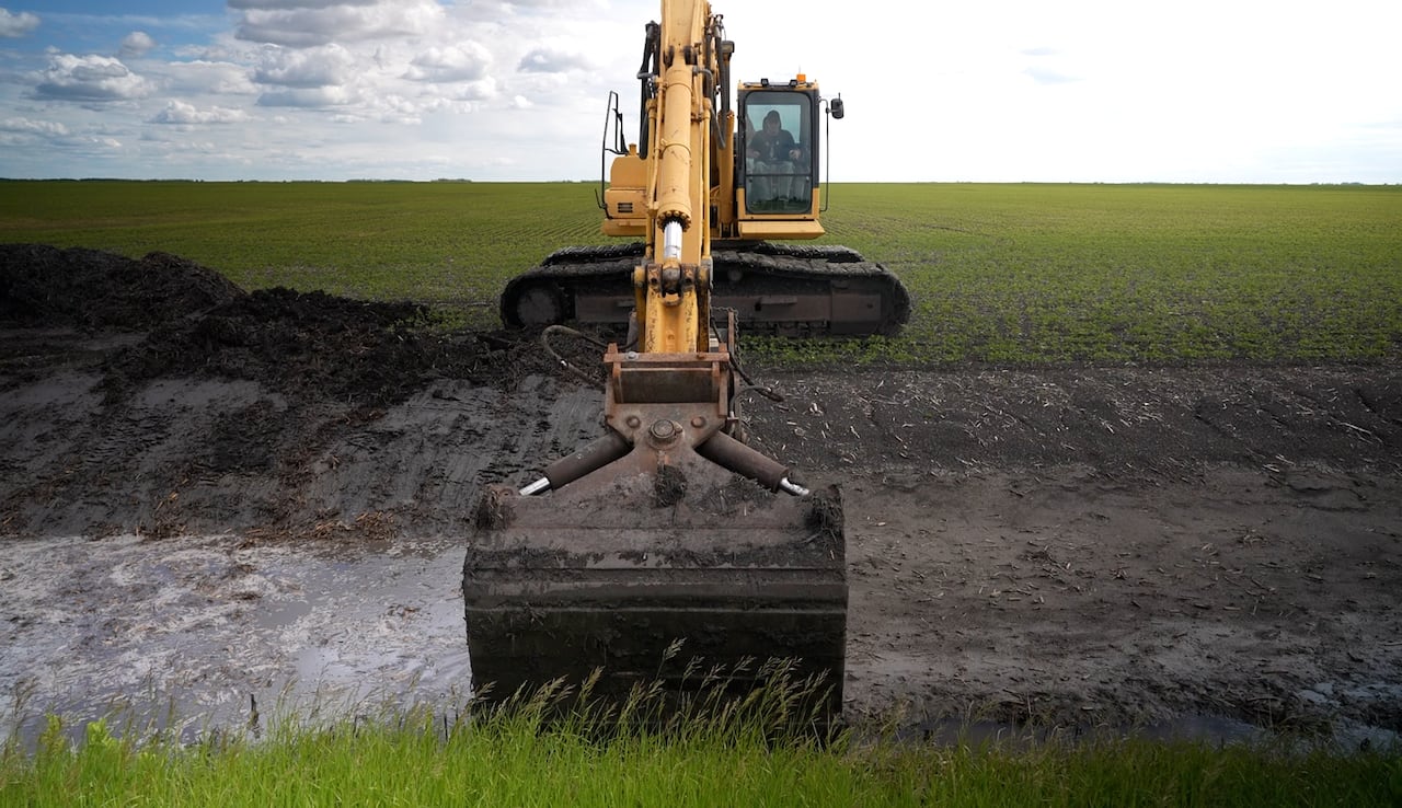 Bucket digs mud