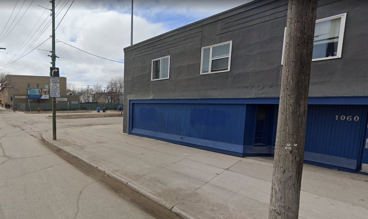 A grey and blue building along a city street with the address numbers 1060
