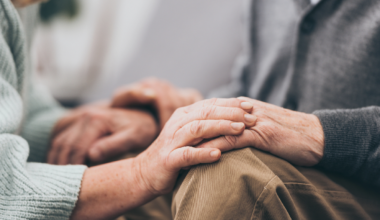 Cropped view of retired couple holding hands