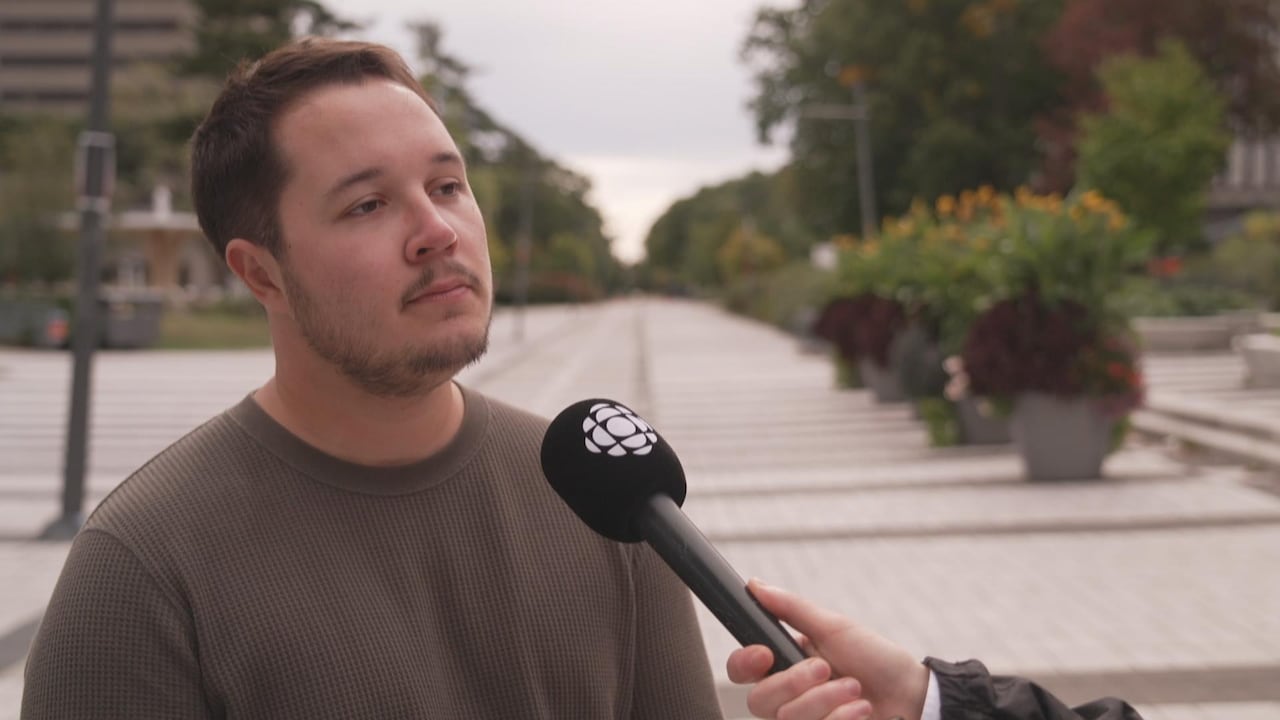 A man speaks into a microphone held by a journalist