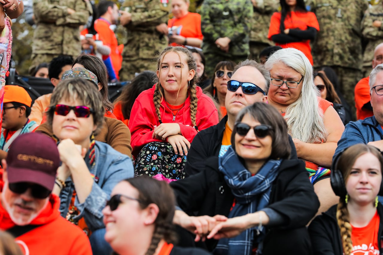 People wearing orange sit together outside.