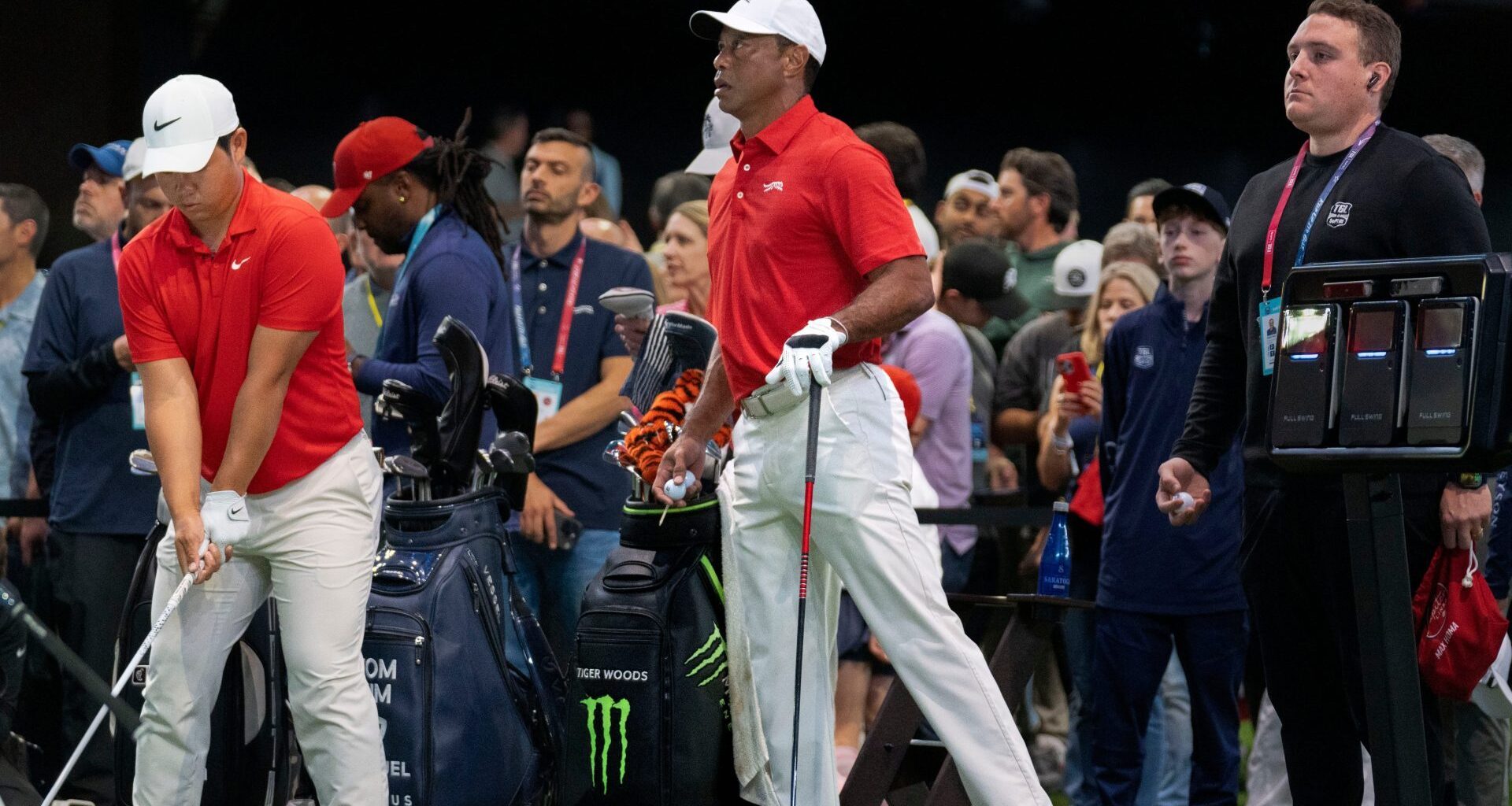 Tiger Woods of Jupiter Links GC stretches his left leg next to Tom Kim during warms up before match against the Los Angeles Golf Club who won the TGL finals at SoFi Center on March 24, 2026, in Palm Beach Gardens, Florida.