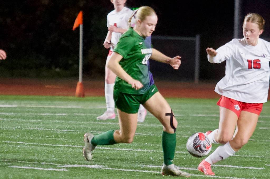 Edmonds-Woodway junior Audrey Rothmier (left) fights for a 50/50 ball against Silas sophomore Allison Conn during the Warriors 1-0 overtime loss to the Rams in the 3A Girls State Soccer Play-in Round at Edmonds Stadium on Nov. 12, 2025. (Joe Pohoryles / The Herald)
