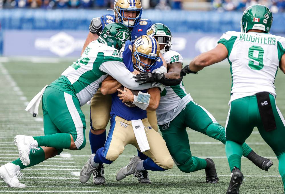 JOHN WOODS / THE CANADIAN PRESS
Winnipeg Blue Bombers quarterback Zach Collaros (8) gets sacked by Saskatchewan Roughriders’ Mike Rose (42) during first half CFL action in Winnipeg on Saturday.