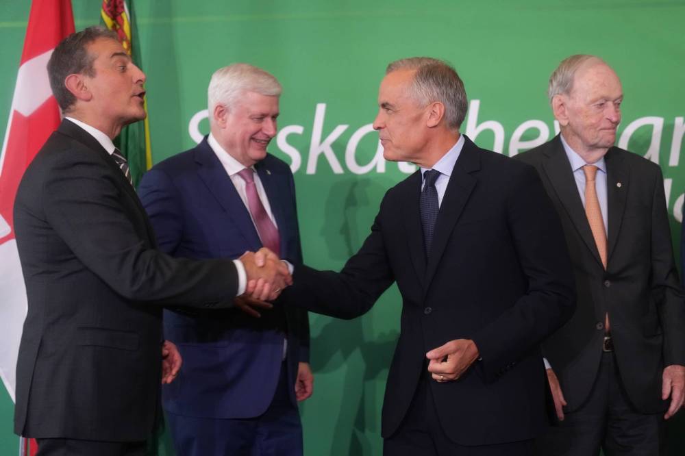 Nathan Denette / The Canadian Press
Bell Canada CEO Mirko Bibic, left, shakes hands with Prime Minister Mark Carney. Former prime ministers Stephen Harper, second from left, and Jean Chrétien, also attended the investment summit.