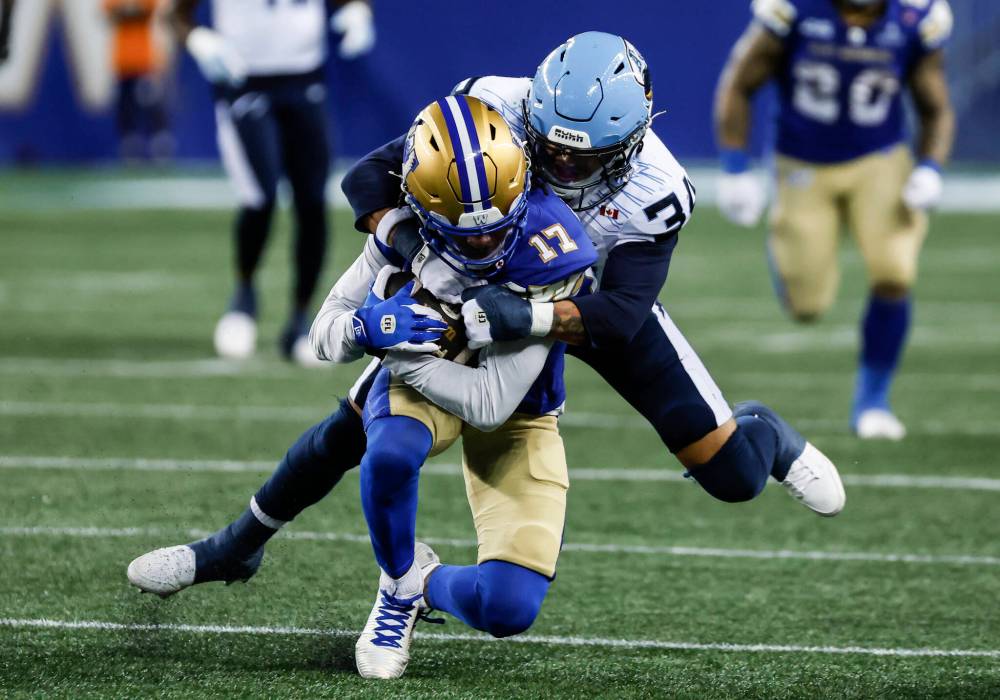John Woods / THE CANADIAN PRESS
Winnipeg Blue Bombers’ Dorian Singer gets tackled by Toronto Argonauts’ Bubba Bolden in the first half in Winnipeg on Friday.