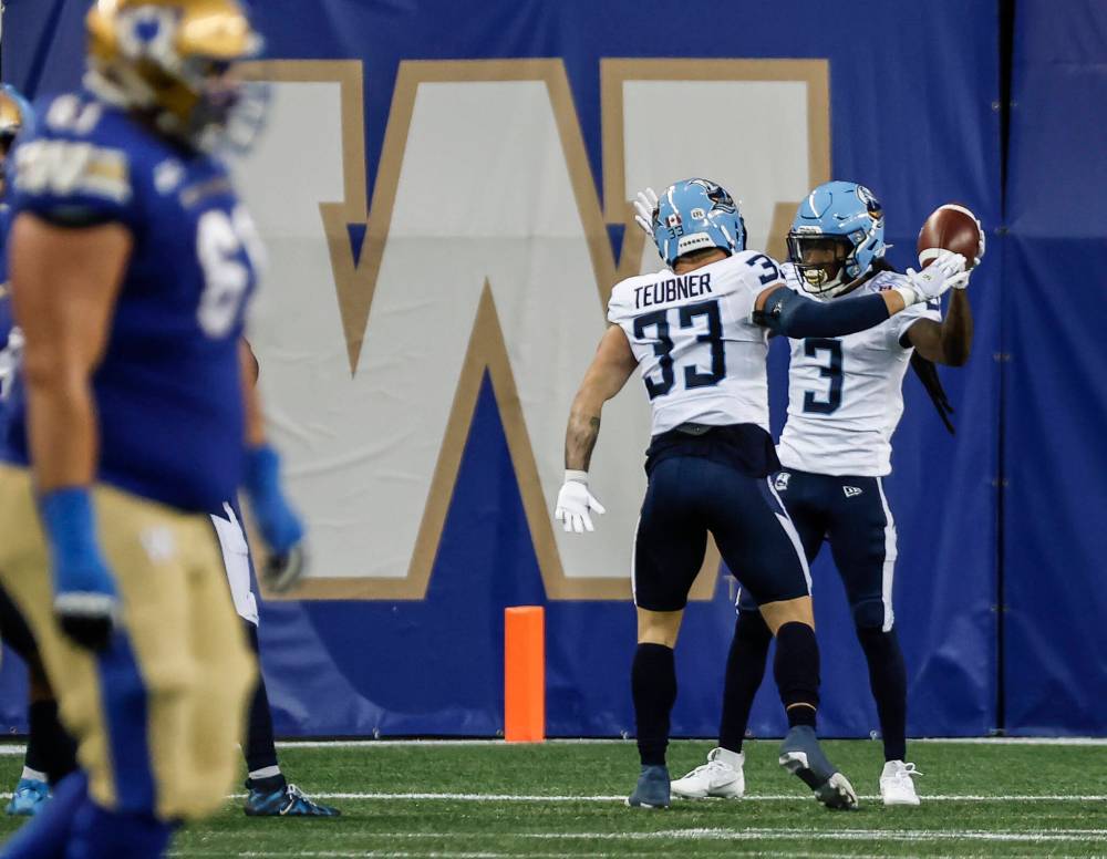 JOHN WOODS / THE CANADIAN PRESS
Toronto Argonauts’ Janarion Grant (3) and Alexander Teubner (33) celebrate Grant’s touchdown after returning Winnipeg Blue Bombers’ failed field goal attempt during the first half in Winnipeg on Friday.