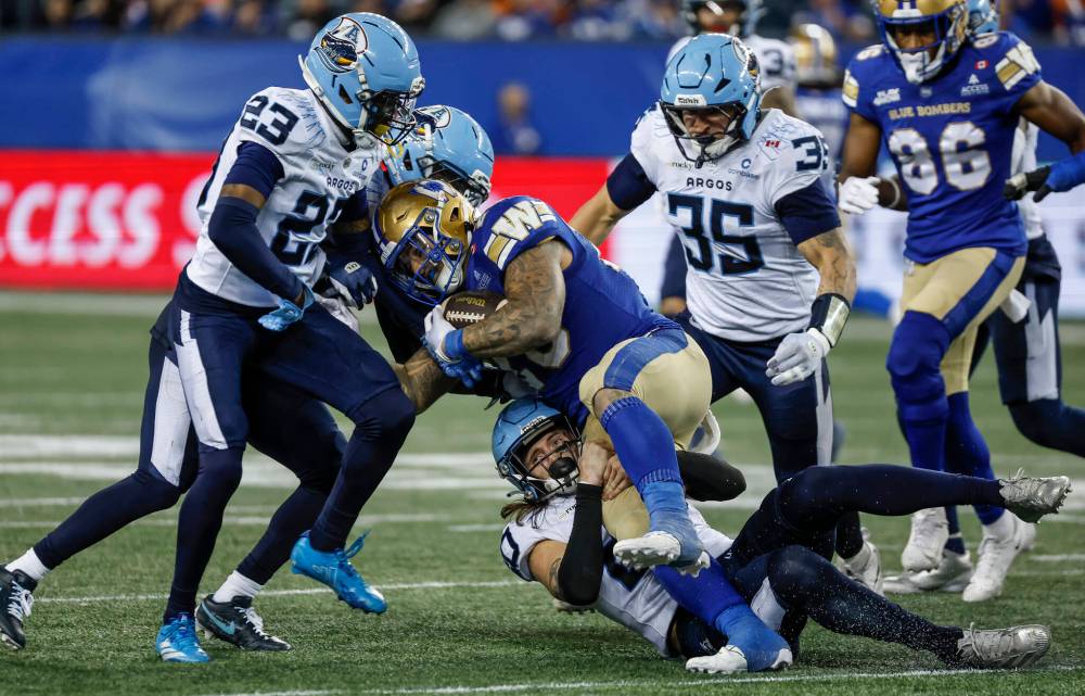 JOHN WOODS / THE CANADIAN PRESS
Winnipeg Blue Bombers’ Brady Oliveira (20) runs for the first down against the Toronto Argonauts during the second half in Winnipeg on Friday.