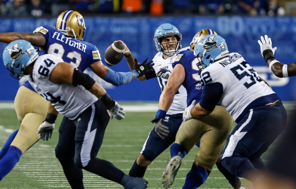 JOHN WOODS / THE CANADIAN PRESS
Winnipeg Blue Bombers’ Micheal Fletcher (93) reaches out to block the pass from Toronto Argonauts quarterback Chad Kelly (12) during the second half in Winnipeg on Friday.