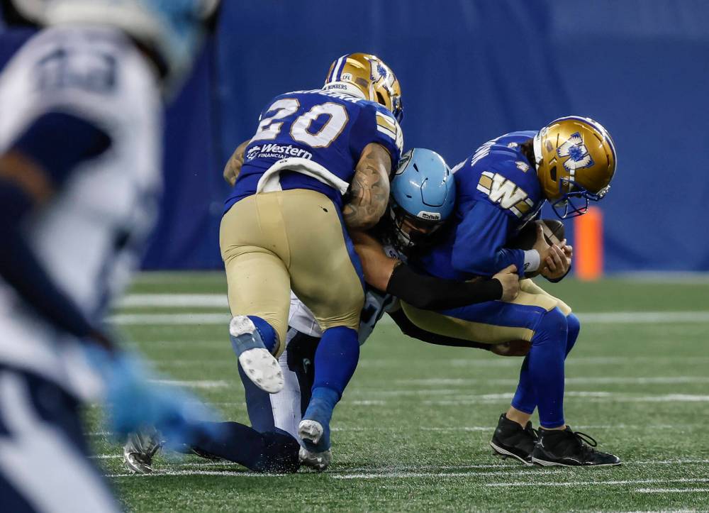 JOHN WOODS / THE CANADIAN PRESS
Winnipeg Blue Bombers quarterback Dru Brown (right) gets sacked by Toronto Argonauts’ Derek Slywka (20) during the second half in Winnipeg on Friday.