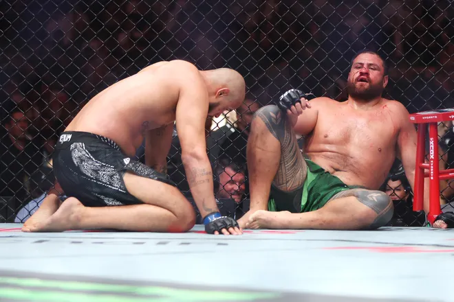 SYDNEY, AUSTRALIA - FEBRUARY 01: (L-R) Tallison Teixeira of Brazil and Tai Tuivasa of Australia sit exhausted after a heavyweight fight during the UFC 325: Volkanovski v Lopes 2 at Qudos Bank Arena on February 01, 2026 in Sydney, Australia. (Photo by Mark Kolbe Photography/Getty Images)