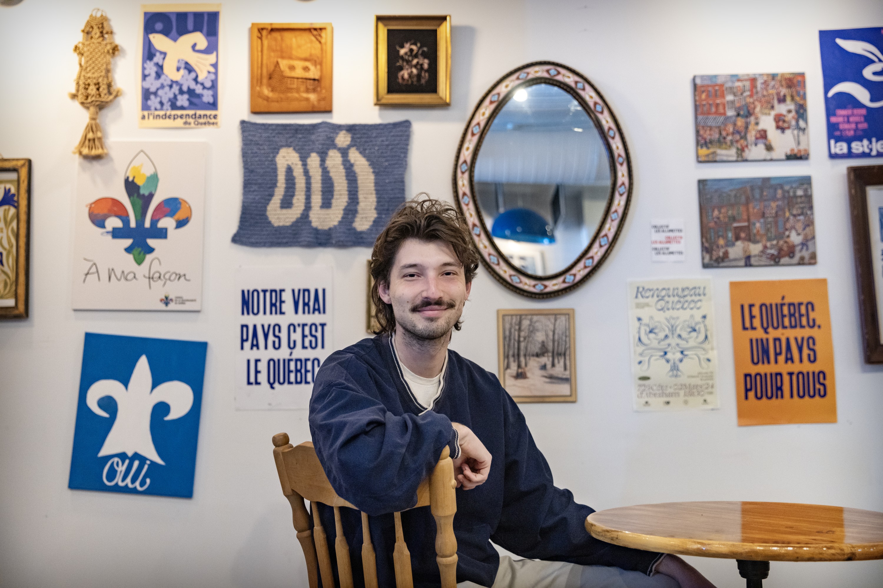 Young man sits posing for picture in sovereignist café.