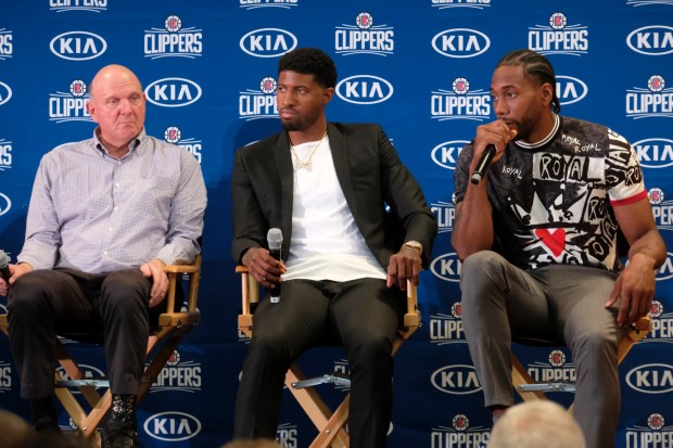 Clippers owner Steve Ballmer, left, and Paul George, center, listen as Kawhi Leonard, right, speaks to the media during an introductory press conference on Wednesday, July 23, 2019, at the Green Meadows Recreation Center in Los Angeles. Ballmer, and many others, expected the Clippers were about to become annual contenders for an NBA title after acquiring Leonard and George that summer, but those dreams never came to fruition and the cost has been considerable. (AP Photo/Ringo H.W. Chiu)
