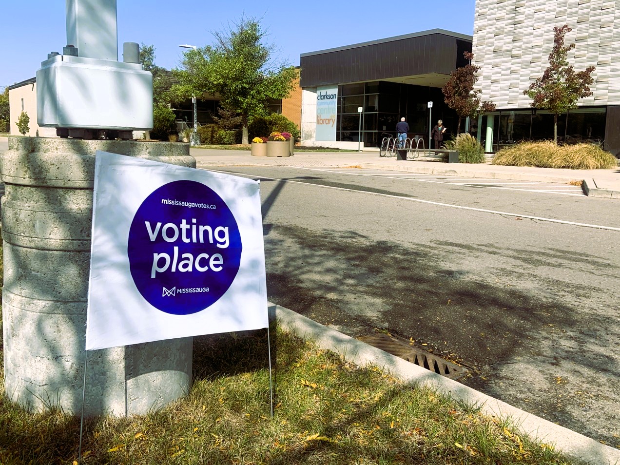 Building with sign in foreground, on grass: "Voting Place."