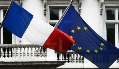 A French and EU flag wave side-by-side in the wind