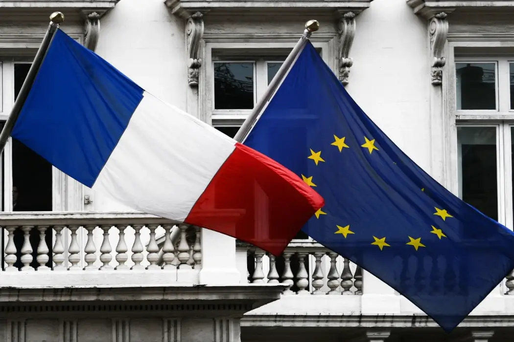 A French and EU flag wave side-by-side in the wind