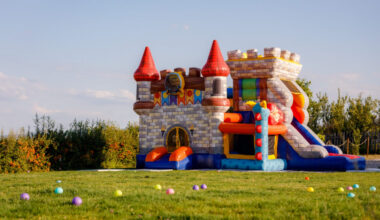 An inflatable castle bounce house sits in green field.