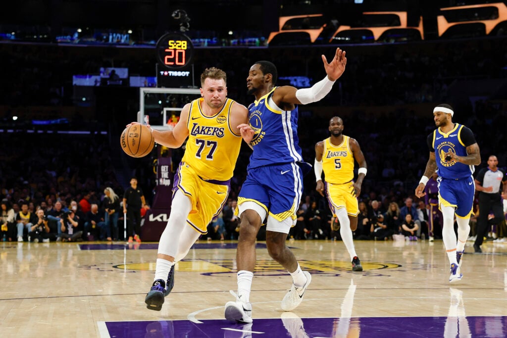 Luka Doncic #77 of the Los Angeles Lakers drives the ball against Jonathan Kuminga #1 of the Golden State Warriors in the first quarter of the game at Crypto.com Arena on October 21, 2025.