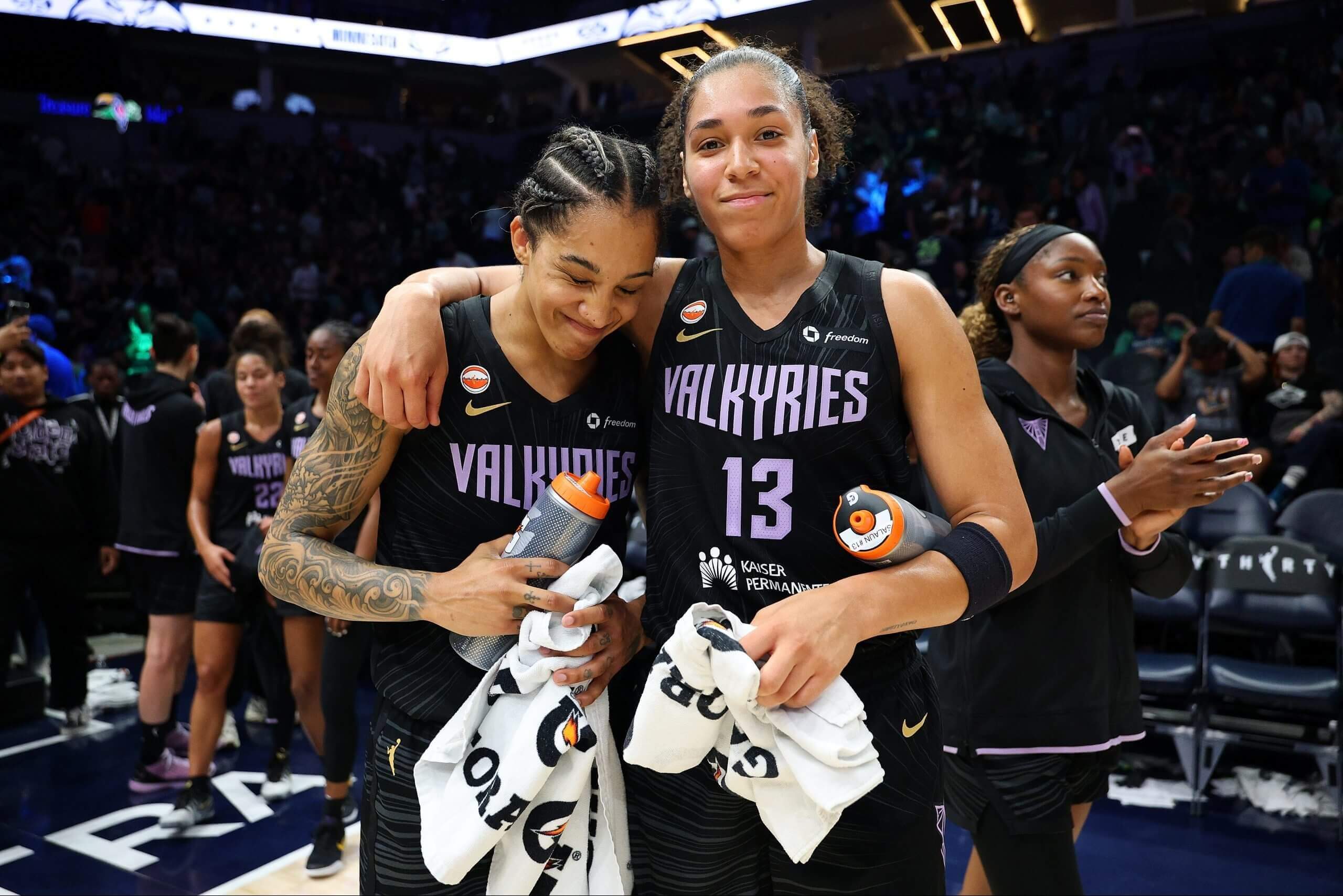 Gabby Williams and Janelle Salaün hold Gatorade towels at a Valkyries game.