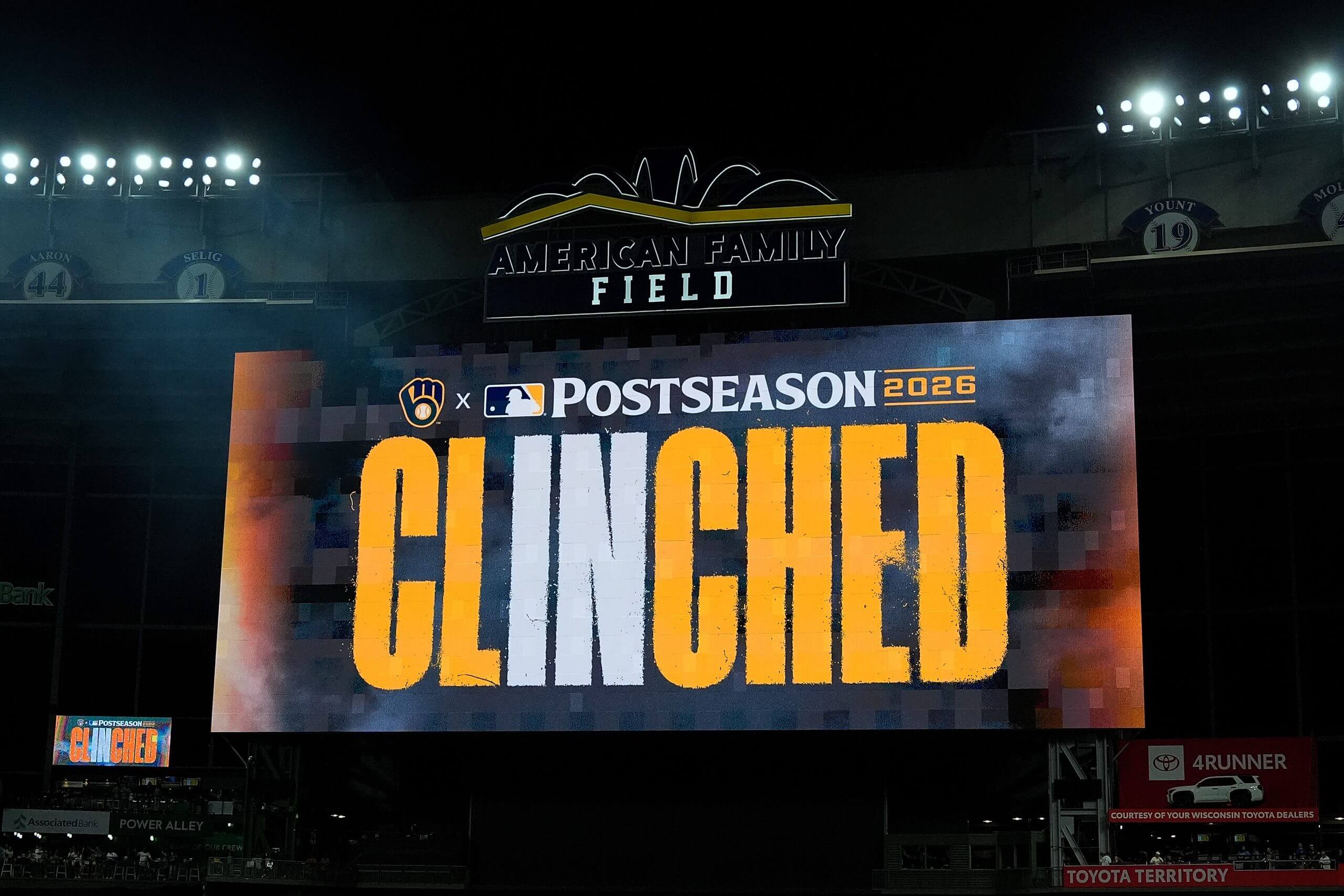 A yellow and white sign that says "Clinched" at American Family Field.