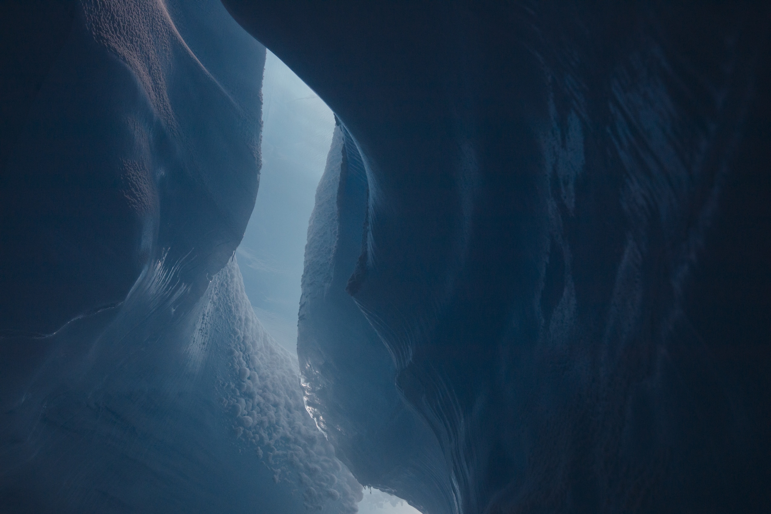 Dramatic lighting and a broad range of turquoise hues emphasize the grandeur of the interior of a glacier.