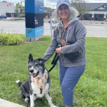 Image of woman smiling next to a dog.